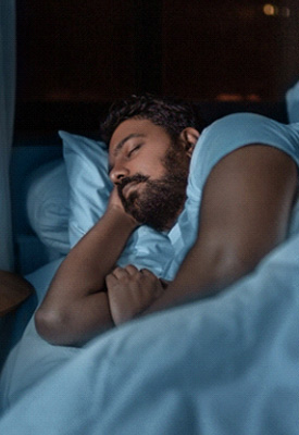 Man sleeping on his side in bedroom